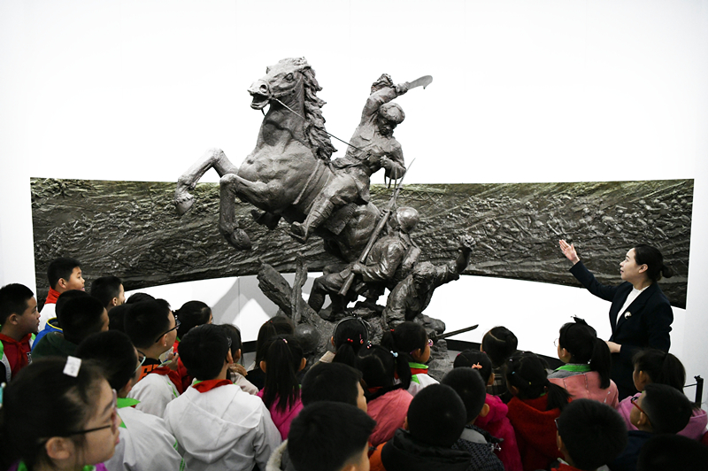 2019年4月4日，在東北烈士紀(jì)念館，學(xué)生們?cè)诼犞v解員講解。